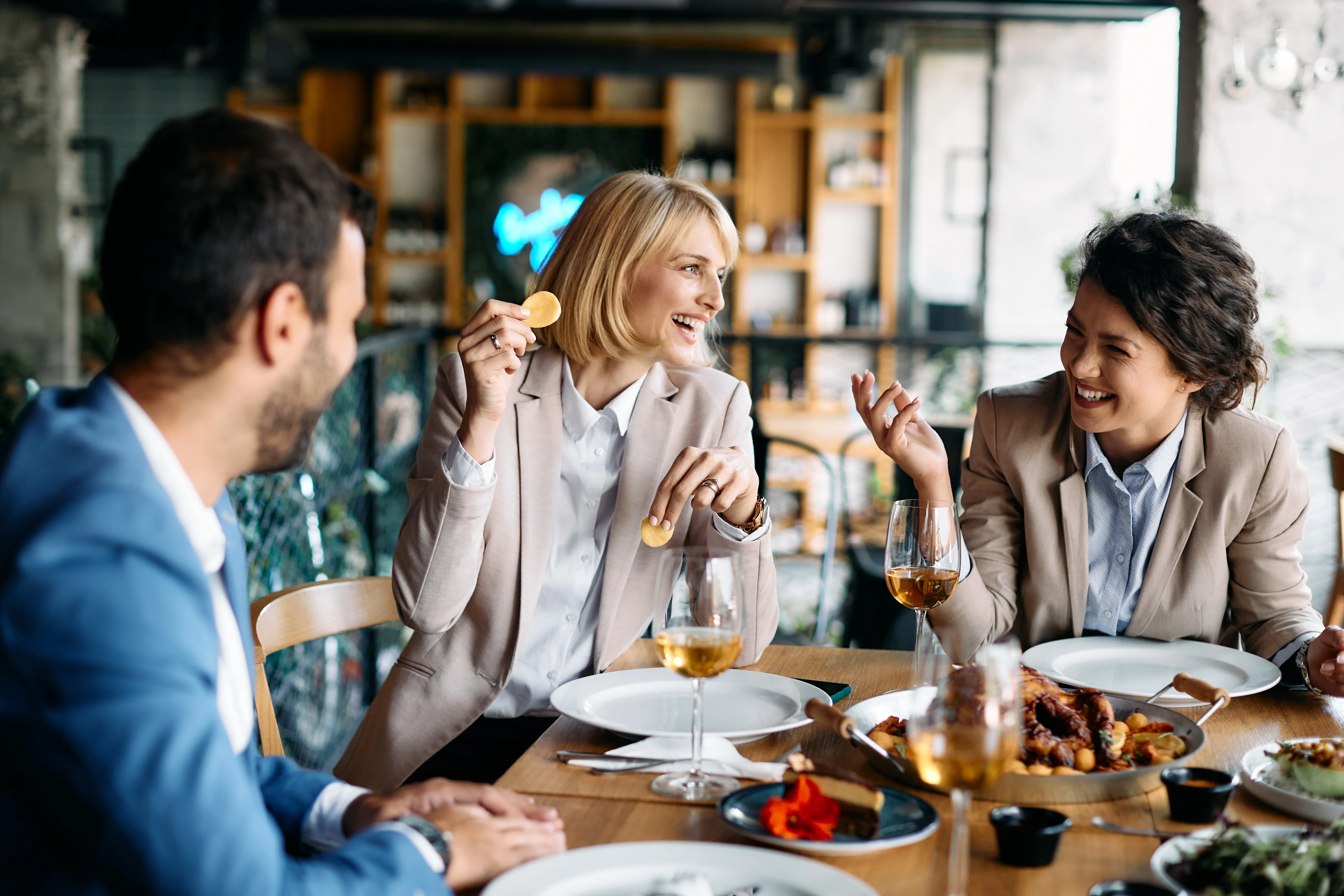 Business colleagues laughing during a restaurant dinner