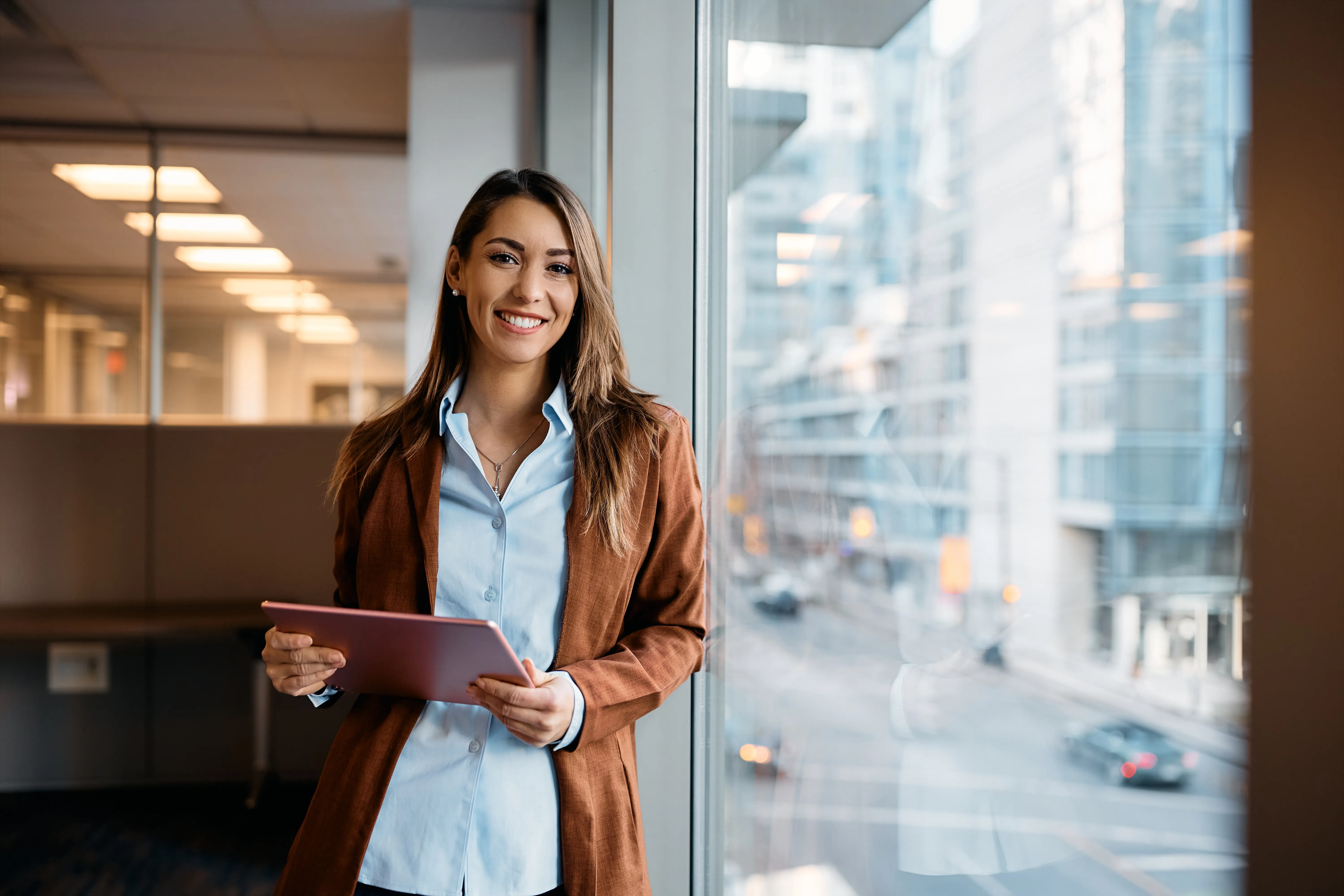 Smiling businesswoman with tablet at the office