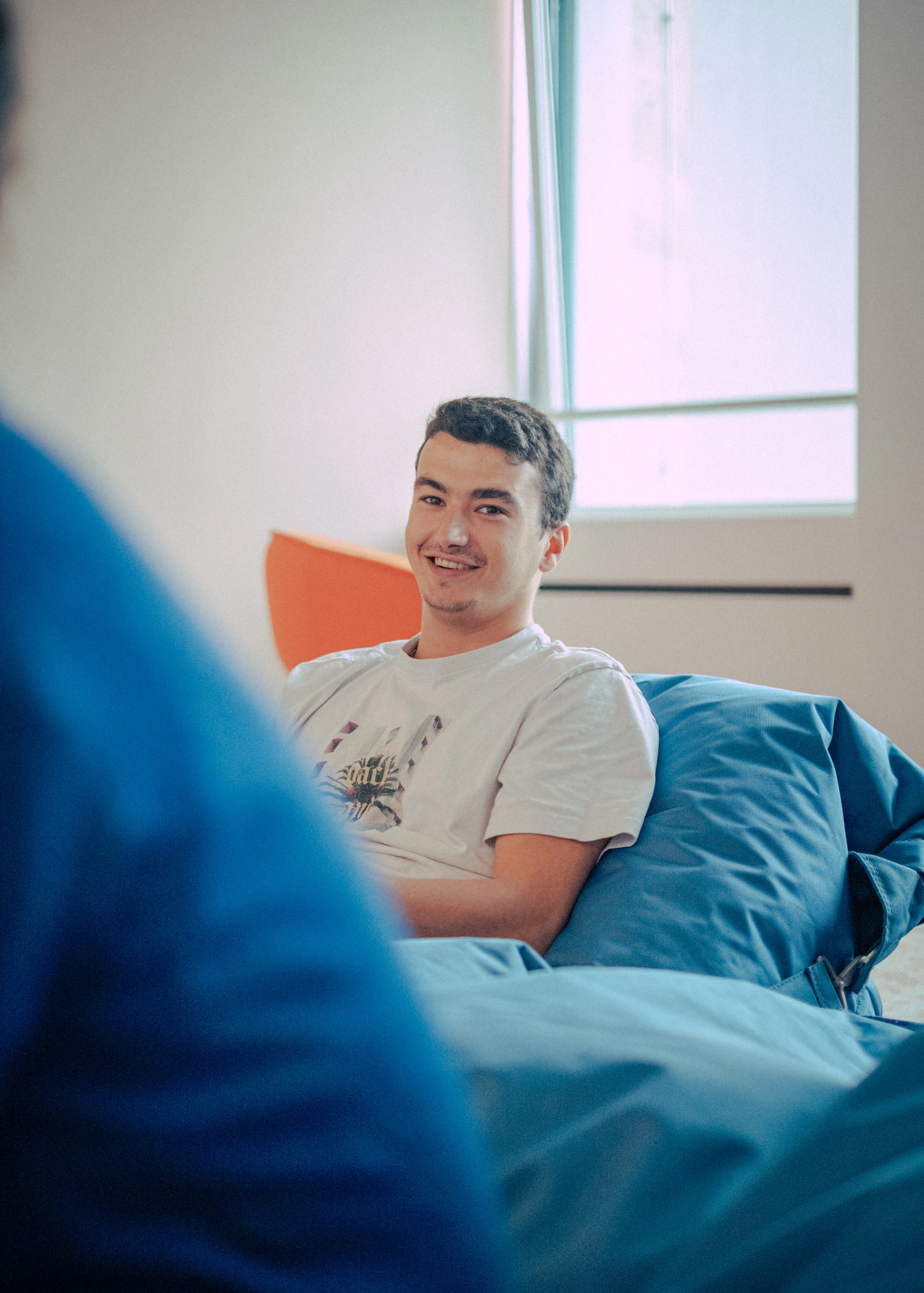 Monizze colleague on a bicycle with helmet, smiling in front of the office