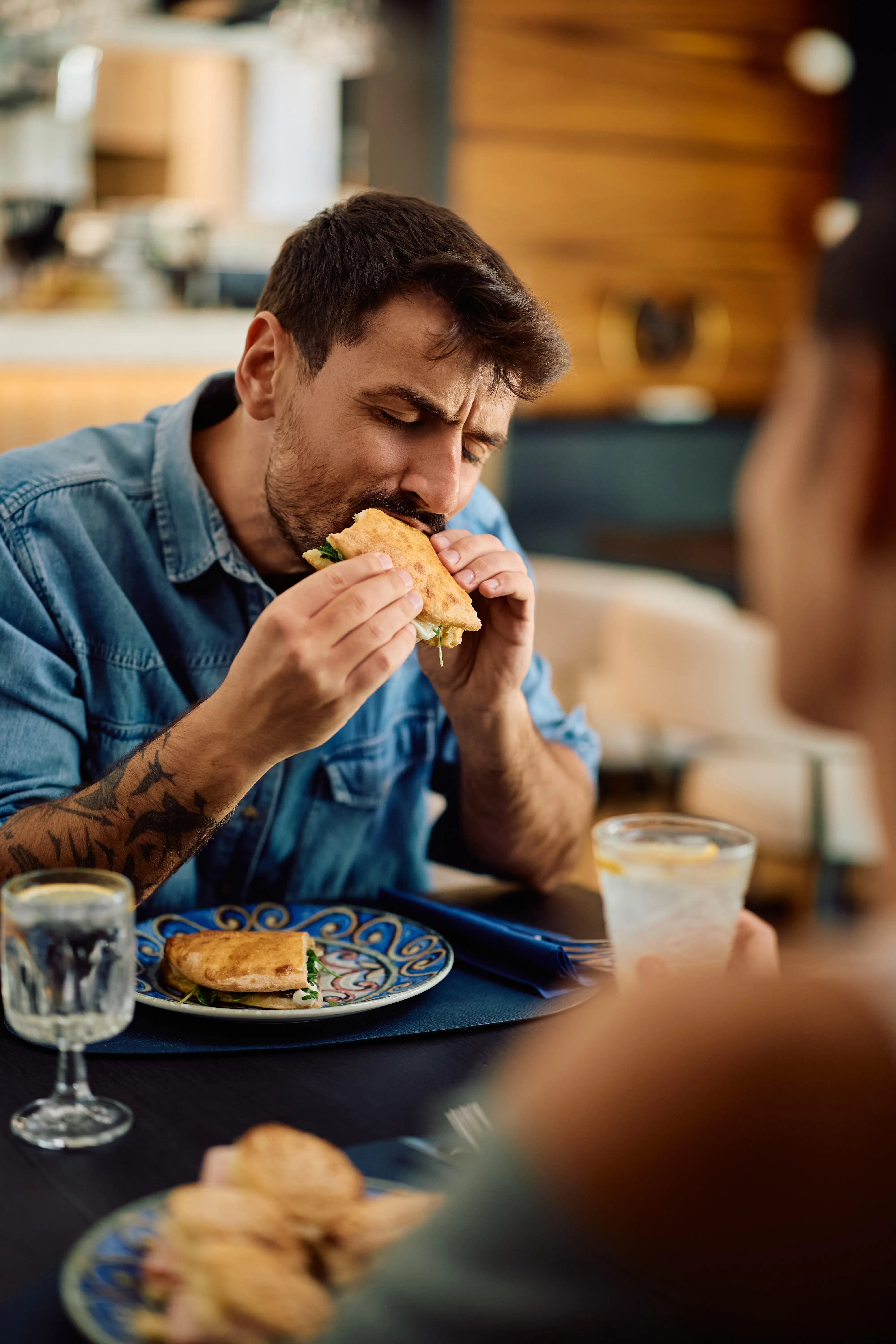 Freelancer enjoying a sandwich at a restaurant during lunch break