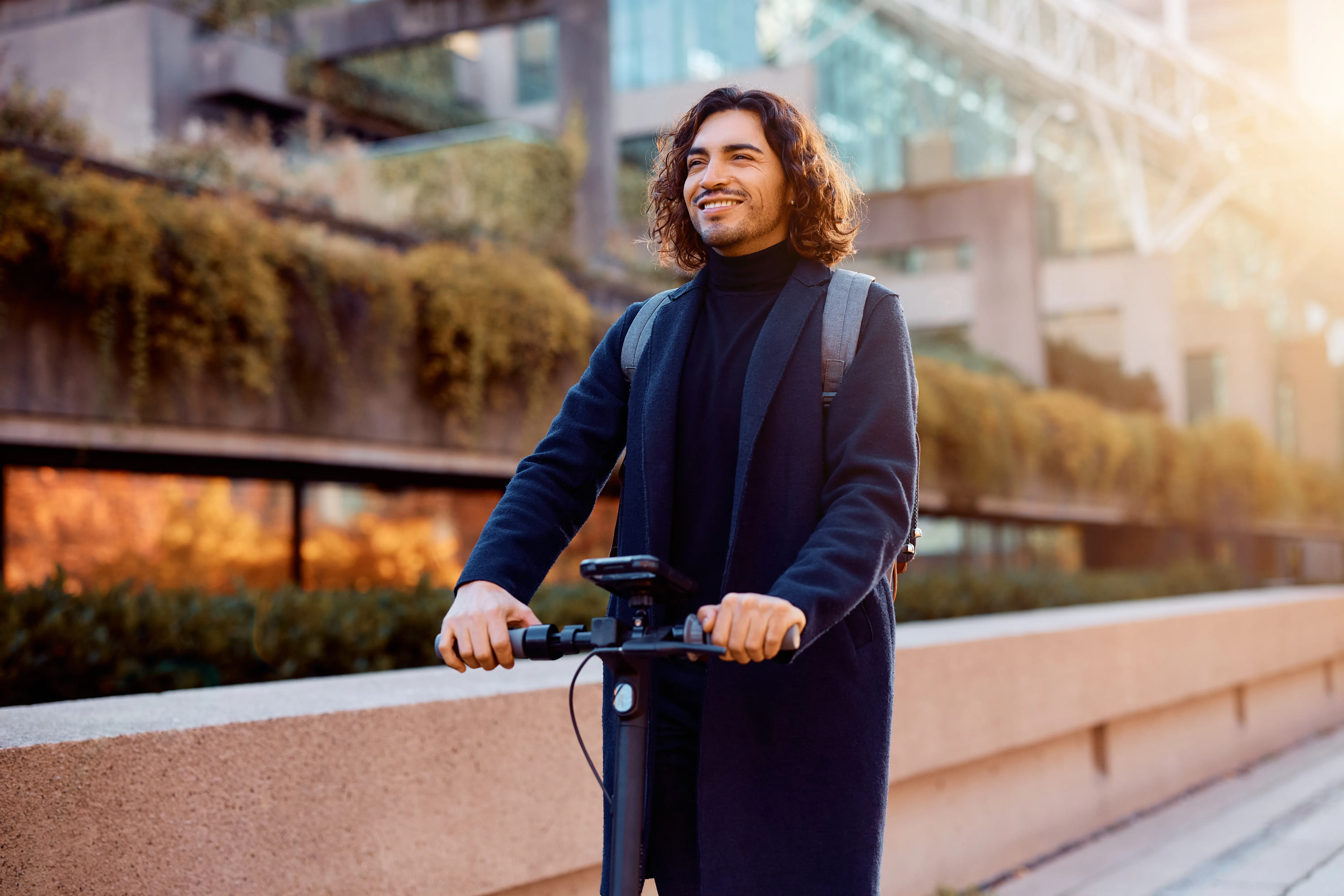 Smiling employee on an electric scooter in the city