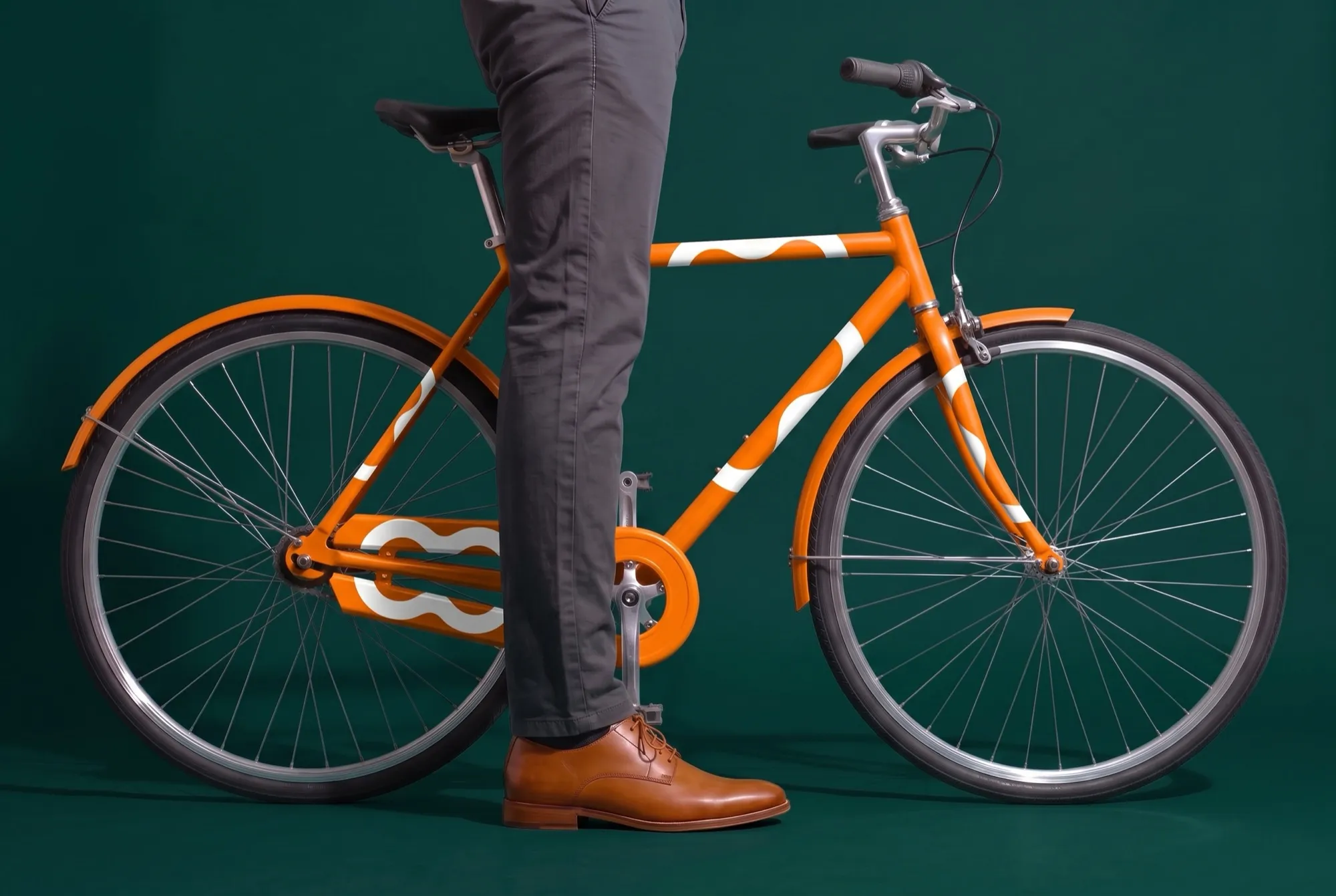 Orange Monizze bicycle against a dark green background
