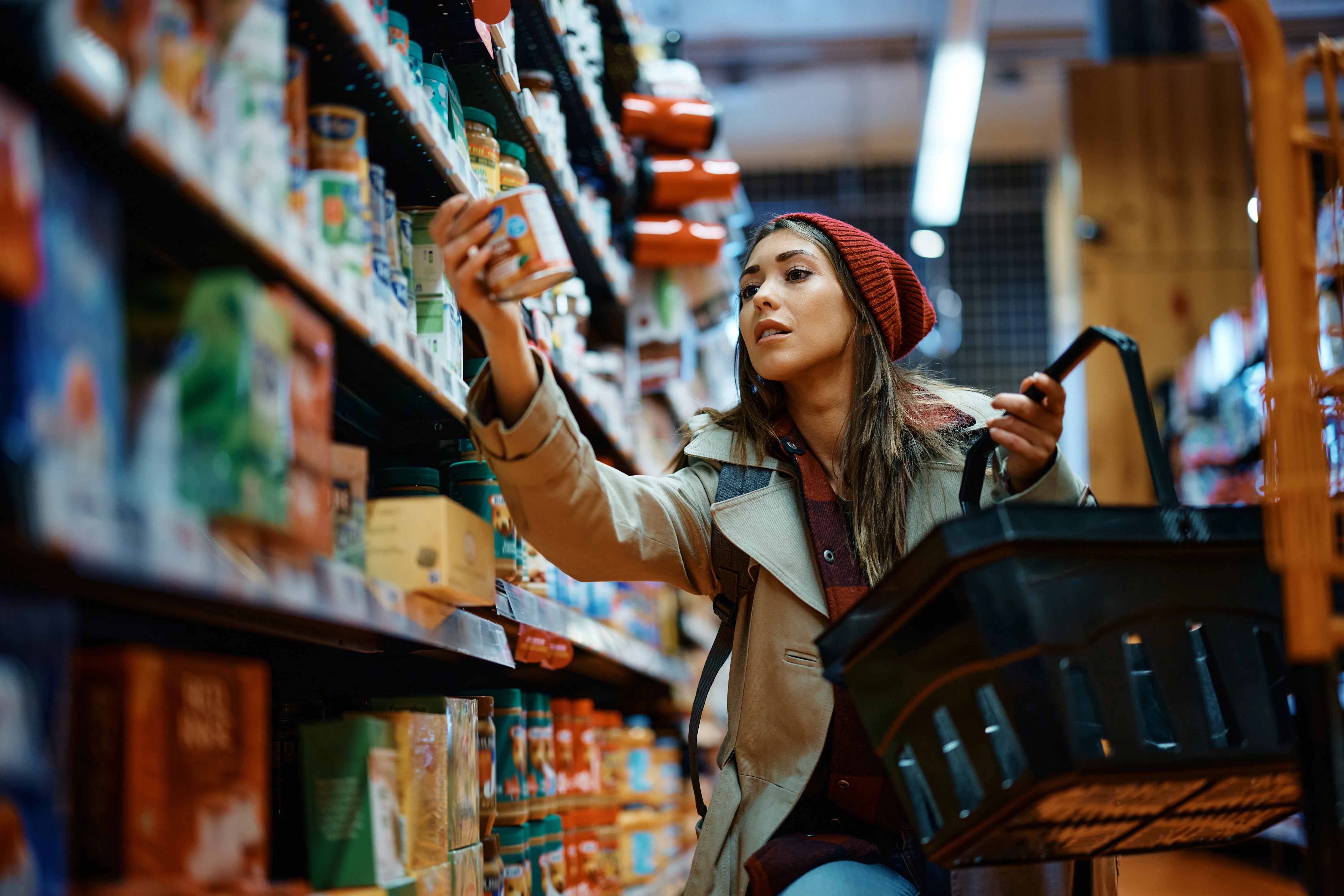 Vrouw die een product kiest in het schap van een supermarkt